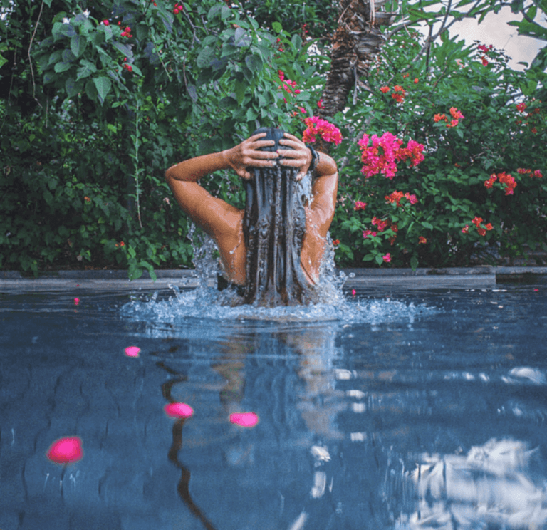 Person coming out of swimming pool with pink flowers