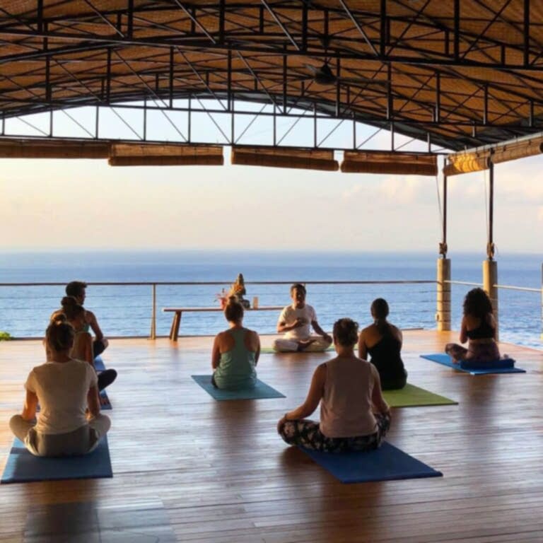 Group of people sitting on a deck overlooking the ocean