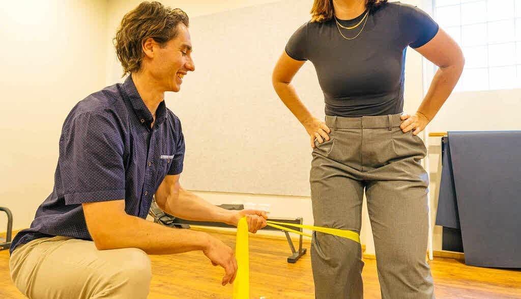 A physio engages in a yoga tune up session with a client